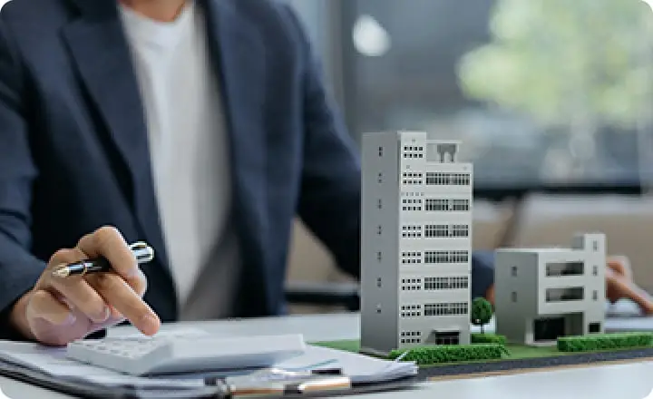 建物の模型を見ながら電卓で計算している様子